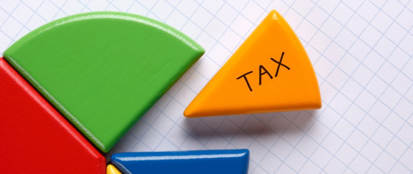 カラフルな円形の積み木の中にTAXと書かれたオレンジの積み木がある